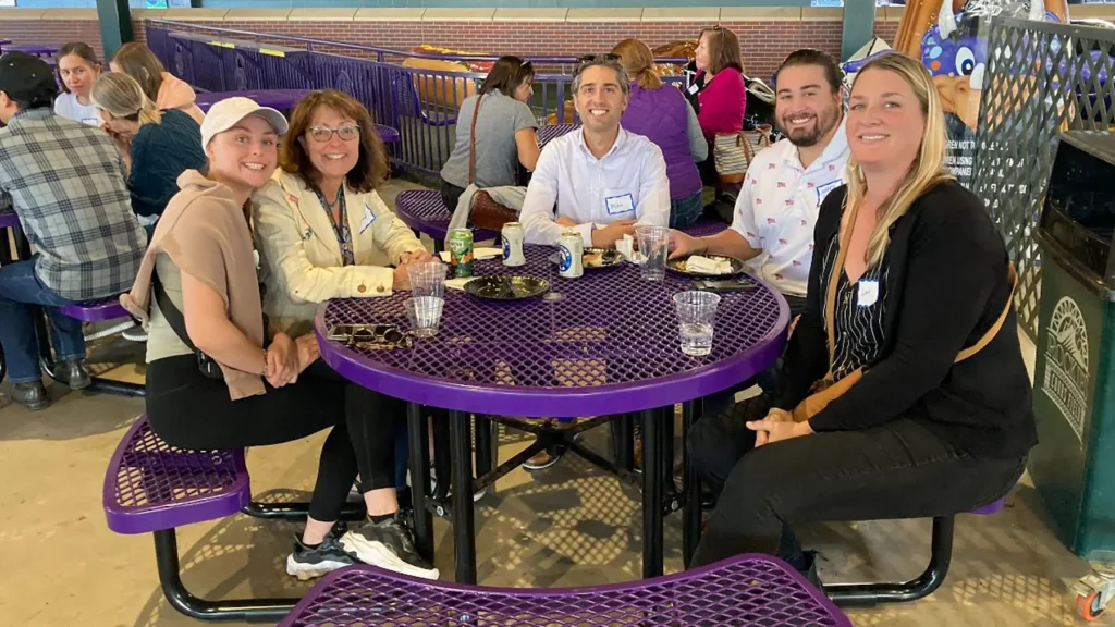 A group of people sit together at a Rockies game
